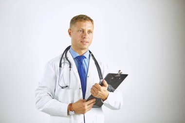 Steteskoplu beyaz önlüklü, kendine güvenen genç bir doktor.