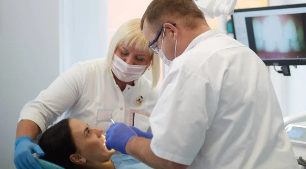 Zahnarzt behandelt Zähne einer schönen jungen Patientin. Das Mädchen an der Rezeption beim Zahnarzt. Zahnarzt behandelt Zahn — Stockfoto