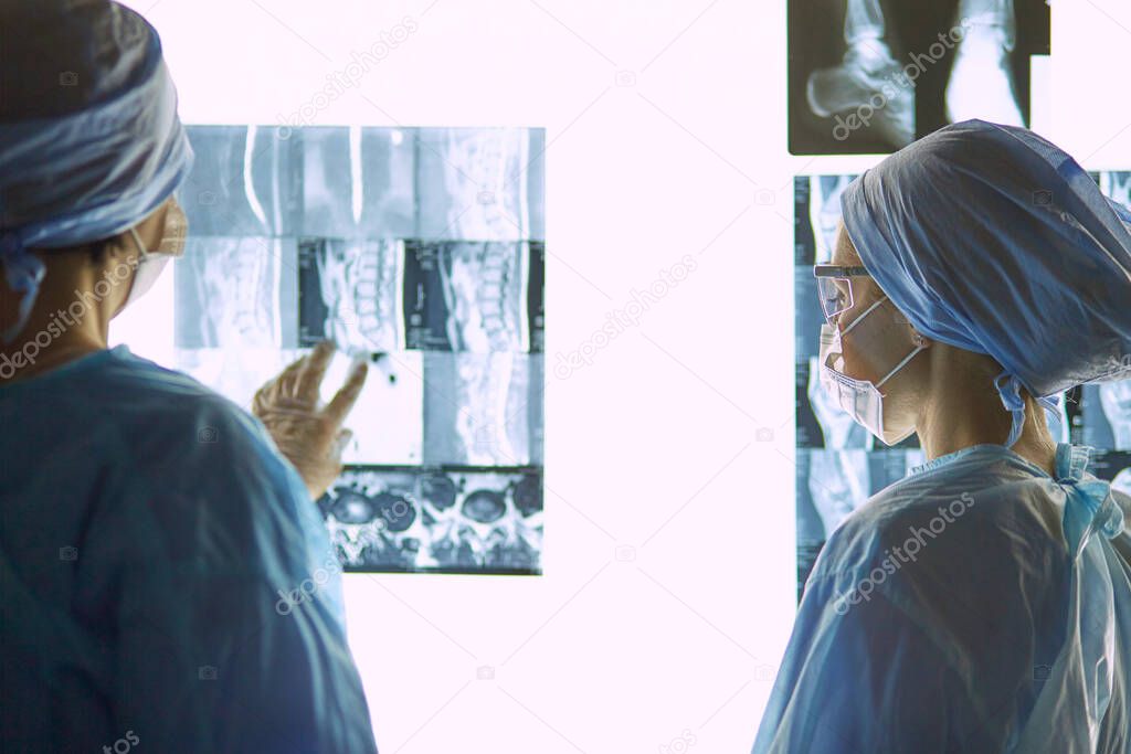 Two female women medical doctors looking at x-rays in a hospita