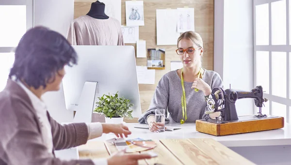 Bonita modista mostrando un nuevo diseño a su cliente — Foto de Stock