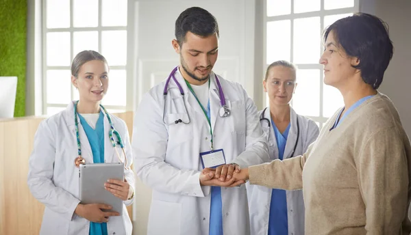 Paziente con un gruppo di medici sullo sfondo — Foto Stock
