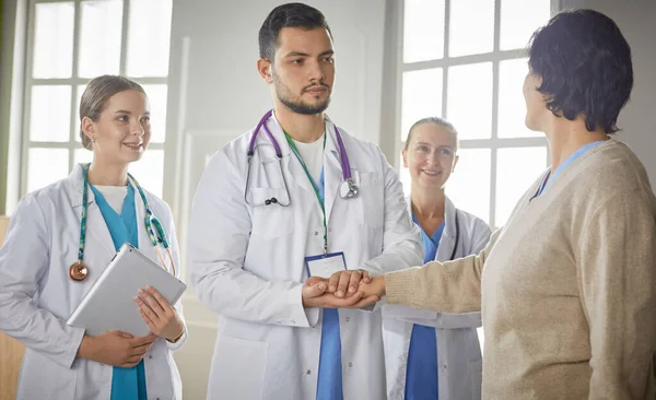 Пациент с группой врачей на заднем плане — стоковое фото