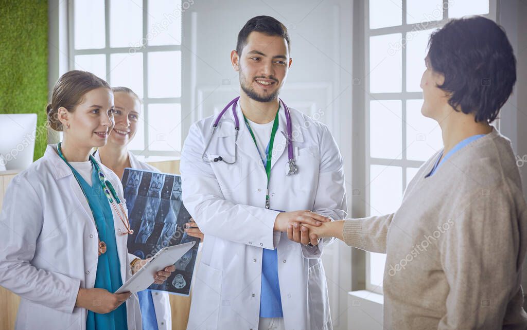 Patient with a group of doctors at the background