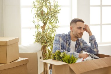 Taşındıktan sonra yeni dairede kutuları olan yakışıklı bir adam.