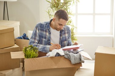 Taşındıktan sonra yeni dairede kutuları olan yakışıklı bir adam.