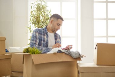 Taşındıktan sonra yeni dairede kutuları olan yakışıklı bir adam.