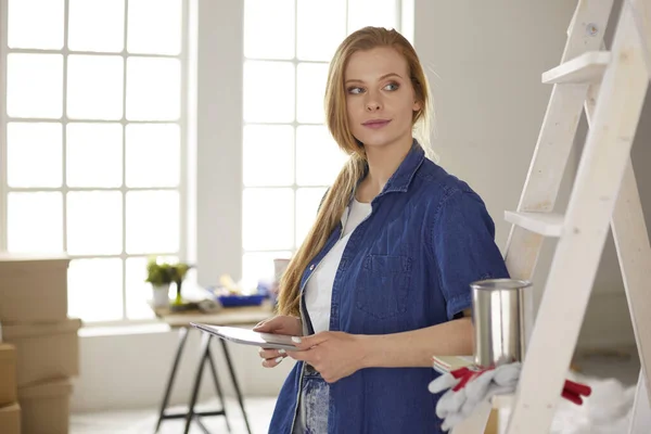 Bella giovane donna su una scala di legno bianca. Pronto a riparare la stanza. Donne concetto di lavori domestici — Foto Stock