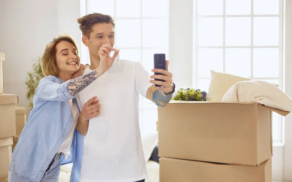 Щаслива усміхнена молода пара показує пару ключів свого нового будинку — стокове фото