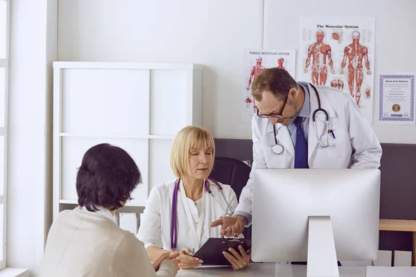 Orta yaşlı erkek doktor bir meslektaşının çalışmasına eşlik ediyor. — Stok fotoğraf