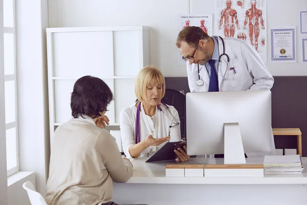 Orta yaşlı erkek doktor bir meslektaşının çalışmasına eşlik ediyor. — Stok fotoğraf