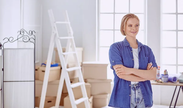 Красивая молодая женщина на белой деревянной лестнице. Готовы отремонтировать комнату. Концепция работы по дому — стоковое фото