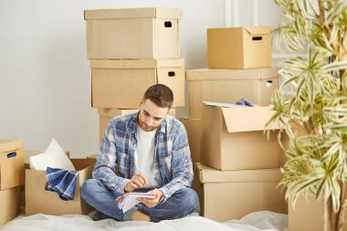 Taşındıktan sonra yeni dairede kutuları olan yakışıklı bir adam.