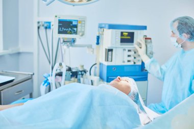 Birkaç doktor hasta operasyon masası üzerinde onların çalışma sırasında çevreleyen. Takım cerrahlar ameliyathane içinde işte
