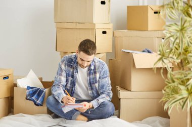 Taşındıktan sonra yeni dairede kutuları olan yakışıklı bir adam.