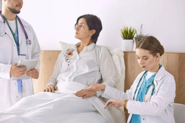 Patient mit einer Gruppe von Ärzten im Hintergrund — Stockfoto