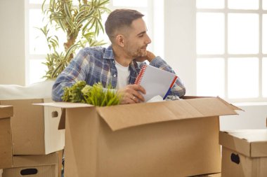 Taşındıktan sonra yeni dairede kutuları olan yakışıklı bir adam.