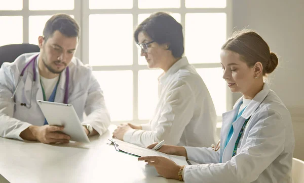 Ung läkare pratar med en patient på kontoret — Stockfoto