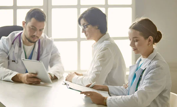 Giovane medico che parla con un paziente in ufficio — Foto Stock