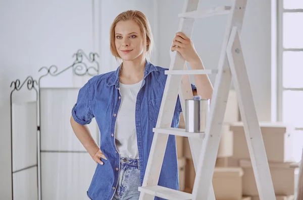 Beautiful young woman on a white wooden stepladder. Ready to repair the room. Women housework concept — Stock Photo, Image