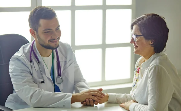 Mladý doktor mluví s pacientem v kanceláři — Stock fotografie