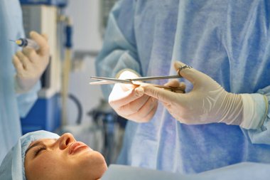 Birkaç doktor hasta operasyon masası üzerinde onların çalışma sırasında çevreleyen. Takım cerrahlar ameliyathane içinde işte