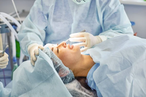 Several doctors surrounding patient on operation table during their work. Team surgeons at work in operating room — Stock Photo, Image