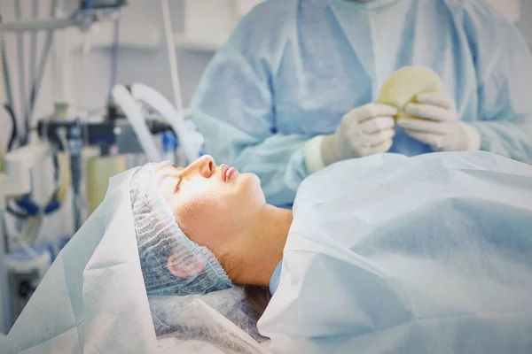 Několik lékařů kolem pacienta na operaci stůl během jejich práce. Tým chirurgů při práci v operačním sále — Stock fotografie