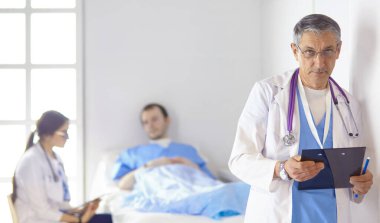 Doktor stetoskop ile yatakta hasta kalp ritmini kontrol