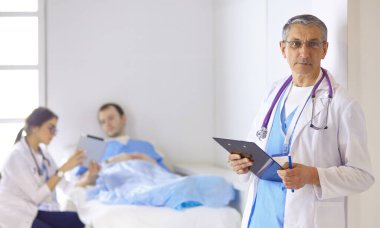 Doktor stetoskop ile yatakta hasta kalp ritmini kontrol