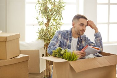 Taşındıktan sonra yeni dairede kutuları olan yakışıklı bir adam.