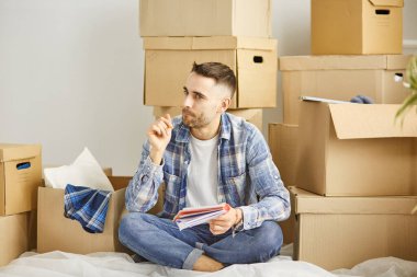 Taşındıktan sonra yeni dairede kutuları olan yakışıklı bir adam.