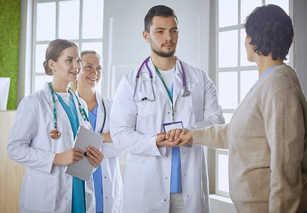 Patient with a group of doctors at the background — Stock Photo, Image