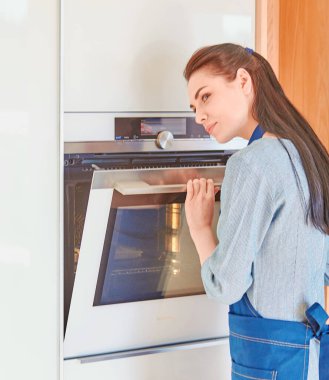 Fırın açık ile bekleyen güzel bir kadın mutfakta