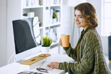 Young woman working with graphic tablet in office clipart