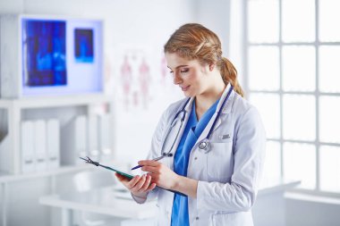 Genç kadın doktor Pano gülümseyerek ile kurulu ile ayakta