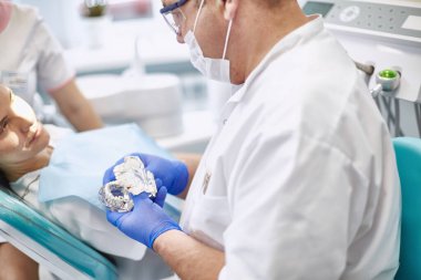 Doktor dişçi genç ve güzel bir kızın dişlerini tedavi ediyor. Dişçinin resepsiyonundaki kız. Doktor dişçi dişleri tedavi eder.