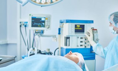 Birkaç doktor hasta operasyon masası üzerinde onların çalışma sırasında çevreleyen. Takım cerrahlar ameliyathane içinde işte