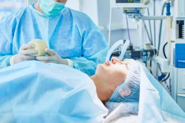 Birkaç doktor hasta operasyon masası üzerinde onların çalışma sırasında çevreleyen. Takım cerrahlar ameliyathane içinde işte