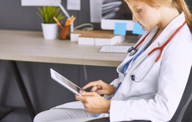 Genç bayan doktor hastasını ofise alıyor.