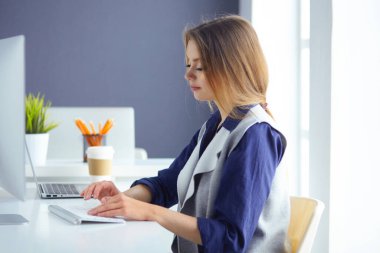 Kulaklığımda odaklanmış özenli kadın laptop ile masada oturur, ekranında görünüyor, notlar yapar, yabancı dil Internet öğrenir