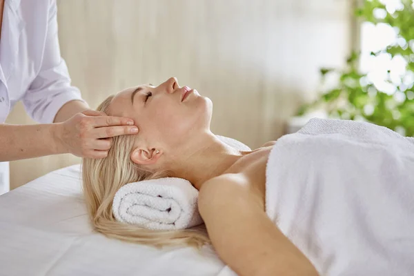 Krásná žena se zavřenýma očima, jak masáž v salonu wellness — Stock fotografie