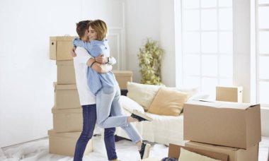 Mutlu genç çift yeni evlerinin anahtarlarını gösteriyor.