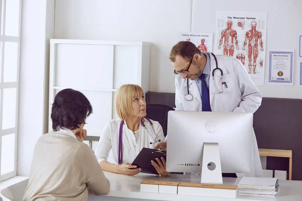 Médico de meia-idade acompanha o trabalho de um colega — Fotografia de Stock