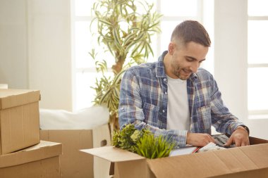 Taşındıktan sonra yeni dairede kutuları olan yakışıklı bir adam.