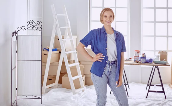 Hermosa joven en una escalera de madera blanca. Listo para reparar la habitación. Concepto de tareas domésticas — Foto de Stock