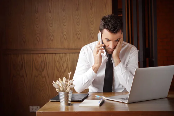 Businessman stressed out while dealing with problem, calling someone and look and computer screen. Can be used for illustration of article about, trading, internet problem, disappoint with service. Stock photo