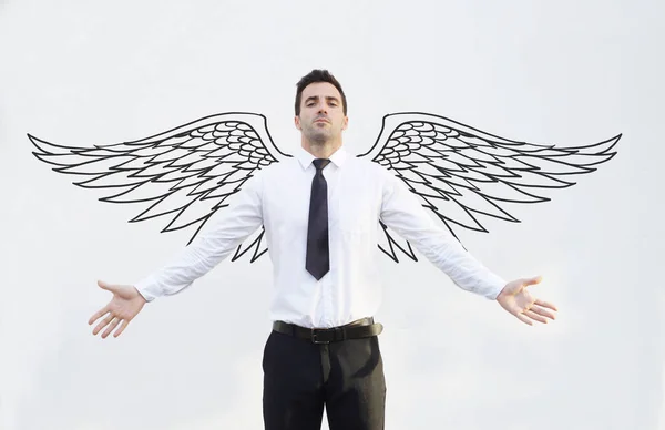 Handsome businessman with hand drawn wings — Stock Photo, Image