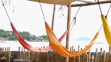 Tayland 'daki Phangan adasında bambu çitli ve deniz manzaralı renkli hamak.