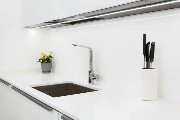Modern tervező chrome vízcsap alatt rozsdamentes acél mosogató. Belső fényes fehér konyha. — Stock Fotó