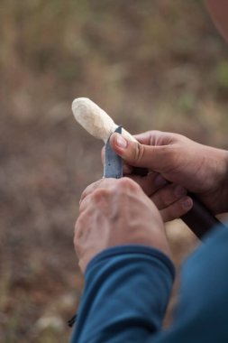 Bir tahta kaşık oyma bir bıçak ile çalışan adamın elleri uygun.